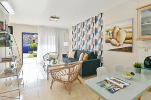 a living room with a couch and a table at Duplex Bahia Meloneras 47 by VillaGranCanaria in Meloneras