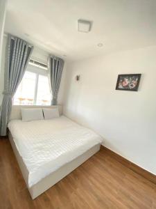 a white bed in a room with a window at Horizon Homestay in Ấp Kim Thạch