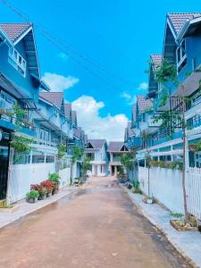 a street with blue houses and a white fence at Horizon Homestay in Ấp Kim Thạch