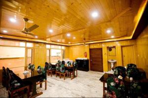 a living room with chairs and a table and a ceiling at Seven Hills Resort Srinagar By Him Haults Hospitality in Srinagar