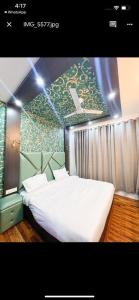 ein Schlafzimmer mit einem großen Bett mit einer Wand mit Avertisation in der Unterkunft Seven Hills Resort Srinagar By Him Haults Hospitality in Srinagar