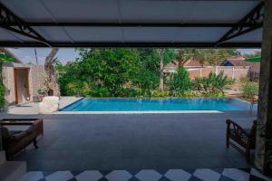 een zwembad in de achtertuin van een huis bij Veranda Java - Traditional & Modern Javanese Villa in Godean