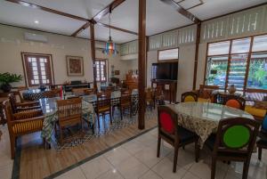 een eetkamer met tafels, stoelen en ramen bij Veranda Java - Traditional & Modern Javanese Villa in Godean