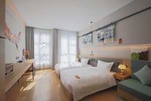 une chambre d'hôtel avec deux lits et un canapé dans l'établissement Timeless Boutique House Shanghai, à Shanghai