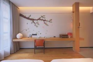 - un bureau dans une pièce avec une branche sur le mur dans l'établissement Timeless Boutique House Shanghai, à Shanghai