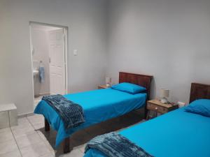 1 dormitorio con 2 camas y baño en Amapondo Backpackers Lodge en Port Saint Johnʼs