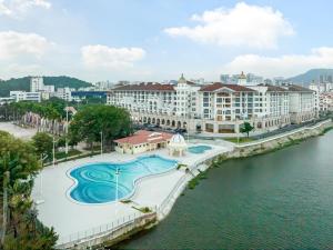 Four Points by Sheraton Yangjiang City Center في يانغجيانغ: اطلالة على منتجع مطل على نهر ومباني