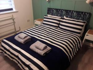 a bedroom with a large bed with two towels on it at The Lodge, countryside living in Churchdown