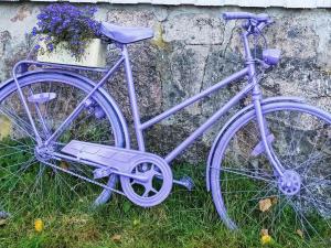 una bicicletta viola parcheggiata nell'erba vicino a un muro di Holiday home Grimstad a Grimstad