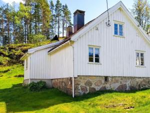 une ancienne maison blanche avec un mur en pierre dans l'établissement Holiday home Grimstad, à Grimstad