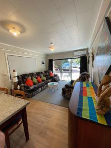 salon z kanapą i kolorowym łóżkiem w obiekcie Swanson-Waitakere Stay in Scenic Sunrise w Auckland