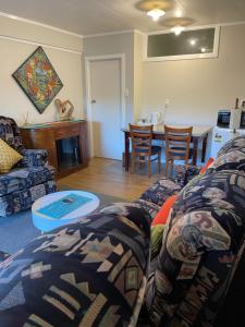 uma sala de estar com um sofá e uma mesa em Swanson-Waitakere Stay in Scenic Sunrise em Auckland