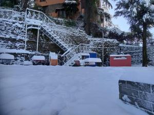 uma escada coberta de neve em frente a um edifício em Glen View Heritage Homestay em Shimla