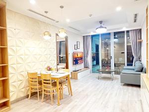 - un salon avec une table, des chaises et un canapé dans l'établissement Luxury Apartment at Vinhomes Central, à Hô-Chi-Minh-Ville