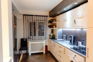 a kitchen with white cabinets and a counter top at Glamour Ultracentral in Craiova
