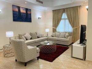 a living room with two couches and a television at Al Misrea Tower in Juffair