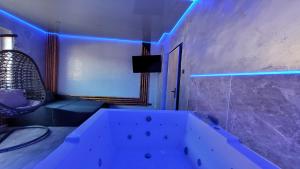 a bath tub in a room with blue lights at Wellness Suite mit Whirlpool und Sauna in Gelsenkirchen