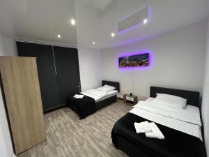 a bedroom with two beds and a purple painting on the wall at Wellness Suite mit Whirlpool und Sauna in Gelsenkirchen