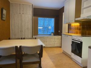 a kitchen with a table and chairs and a table and a stove at Apartment HILLI in Rovaniemi