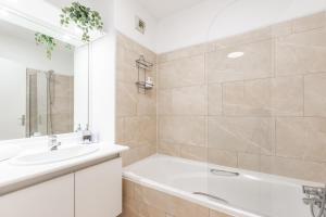 a white bathroom with a tub and a sink at Artémis-10 min. from Versailles Gardens, parking in Le Chesnay