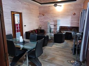 科托努Magnifique appartement的一间有桌椅和钢琴的房间