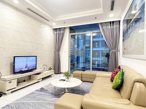 - un salon avec un canapé et une télévision dans l'établissement Luxury Apartment at Vinhomes Central, à Hô-Chi-Minh-Ville