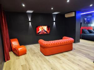 a living room with an orange couch and a fireplace at LoveRoom#1 by Pimente ton couple in Cagnes-sur-Mer