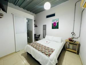 Un dormitorio con una cama y una mesa. en Hostal Bon Hábitat en Yopal