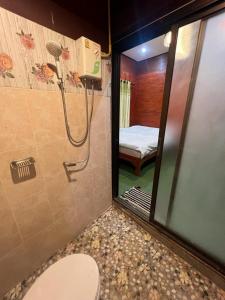 a bathroom with a shower with a toilet and a bedroom at Aya House in Pai
