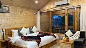 a bedroom with a bed and a couch in a room at Tree house Latos Tandi in Jibhi