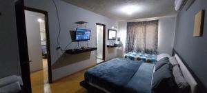 a bedroom with a bed and a mirror and a television at Apartamento con cochera centro de la ciudad. in La Paz