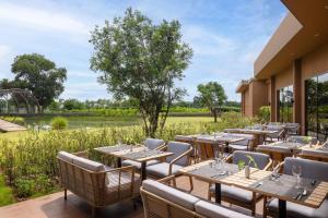 a restaurant with tables and chairs on a patio at Dusit Princess Phatthalung in Phatthalung
