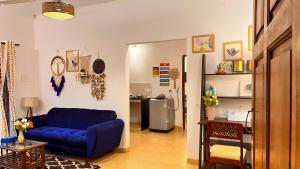 - un salon avec un canapé bleu et un réfrigérateur dans l'établissement Dreamy Boho Haven, à Vagator