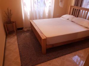 ein Bett auf einem Teppich in einem Schlafzimmer in der Unterkunft Avacado Homestay in Arusha