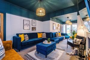 a living room with blue couches and yellow pillows at Cabin Hill in Colwyn Bay