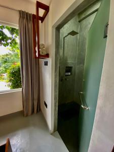 uma casa de banho com uma porta verde e uma janela em Sesatha lake Kandy em Kandy