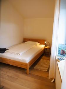 uma cama num pequeno quarto com piso em madeira em Alte Seifensiederei - Astrid em Bad Tölz