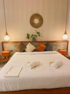 Un dormitorio con una cama blanca con dos toallas encima. en Bali Crystal Beach Villas #9, en Salad Beach