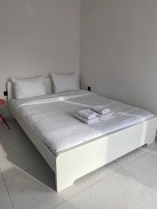 a white bed with white sheets and pillows on it at Seaview by Agora Flats in Thessaloniki