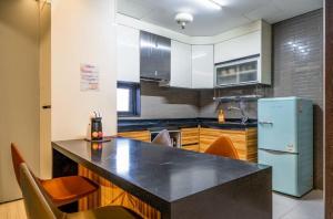 a kitchen with a black counter top and a refrigerator at Stay 247 in Gimhae