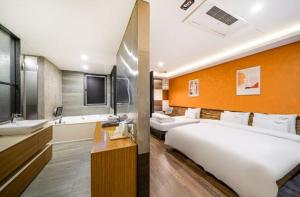 La salle de bains est pourvue d'un grand lit blanc et d'un lavabo. dans l'établissement Stay 247, à Gimhae