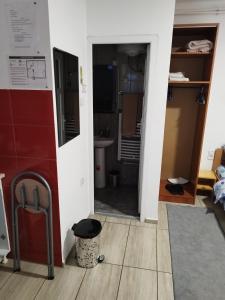 - une porte menant à une salle de bains pourvue d'un lavabo et d'un miroir dans l'établissement Soba Milica, à Palić
