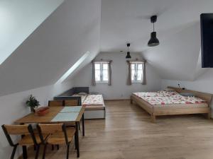 a attic room with two beds and a table at Apartmány Ema a Ela in Tatranska Strba