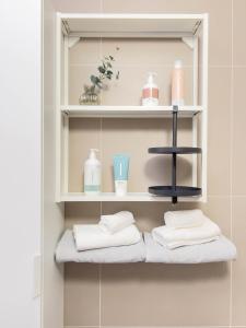 a bathroom with shelves with towels on them at Oradea Comfort Corner in Oradea