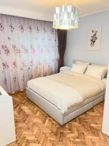 a bedroom with a bed and a chandelier at Oradea Comfort Corner in Oradea