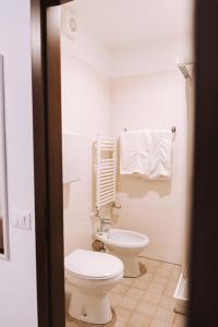ein weißes Bad mit einem WC und einem Waschbecken in der Unterkunft Casa Camilla in St. Michael an der Etsch