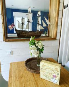 una mesa de madera con un modelo de barco en un espejo en La villa plein vent "La Bounty" gite 50m de la plage, en Barneville-Carteret
