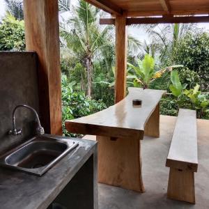 a outdoor kitchen with a sink and a bench at Bali jungle cabin in Jatiluwih
