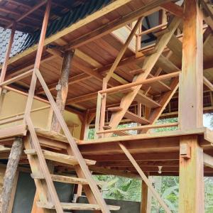 a wooden house under construction with wooden beams at Bali jungle cabin in Jatiluwih