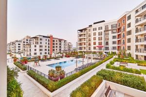 an apartment complex with a swimming pool and buildings at Majestic La MER La Voile1 - Jumeirah 1- Swimming pool view in Dubai